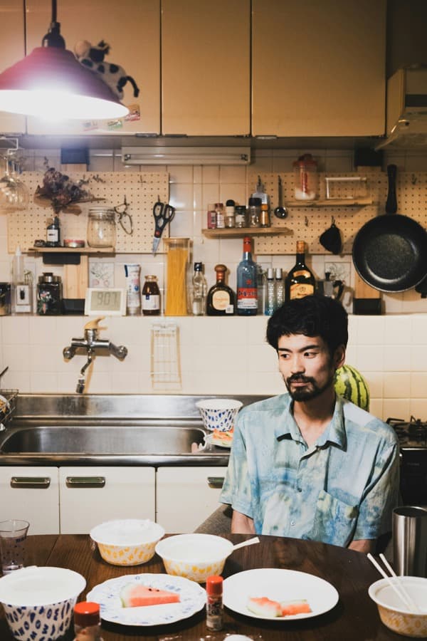 A man sitting at a kitchen table at home.